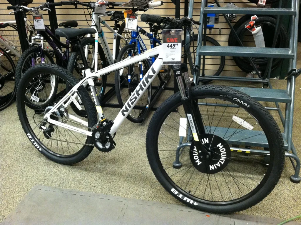 White Nishiki mountain bike displayed in a bicycle shop with price tag.